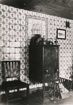 Gefliestes Wohnzimmer in einem friesischen alten Bauernhaus bei Husum. In der Bildmitte ein gusseisener Ofen