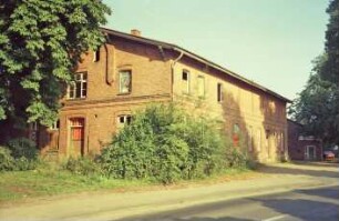 Am Markt (10): traufständiges Backsteingebäude mit umlaufendem Gesims: Straßenfront mit zwei Eingangstüren, in Oberschoss rechts Schlitzfenster: Giebelseite mit Seitentür: hinten rechts Haus