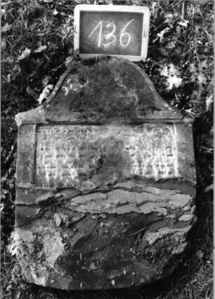 Grabstein 136 (Index: 100090327) Material: Sandstein Zustand: beschäd. /verwittert mit Textverlust Maße HxBxT: 0x0x0 cm Beschreibung: Stele, Konvexbogenabschluß, rechteckiges Schriftfeld eingetieft: Grabstein 136