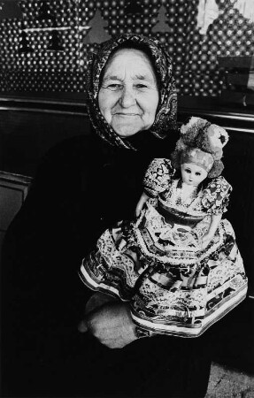 Alte Frau mit einer Puppe