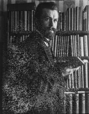 Rudolf Zimmermann : Portrait von Rudolf Zimmermann vor einem Bücherregal.
