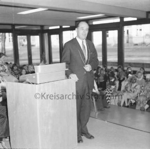 Stadtschule: Salinenstraße: Einweihung des Neubaus: Rektor Karl Heinz Goldenbaum mit symbolischem Generalschlüssel an Kette neben Rednerpult: hinten Schulkinder: 13.01.1973