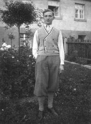 Junger Mann mit Knickerboxerhose und Strickweste