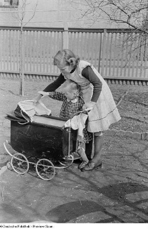 Mädchen mit einem Puppenwagen