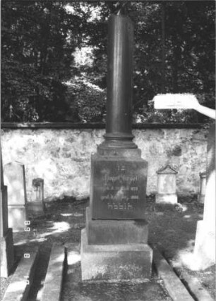 Grabstein 85 (Index: 100105817) Material: polierter Granit auf ? Zustand: sehr gut Maße HxBxT: 232x48x48 cm Beschreibung: abgebrochene Säule auf getrepptem Sockel Symbolik: abgebrochene Säule: Grabstein 85