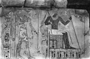 Der König auf dem Thron, hinter ihm Anubis