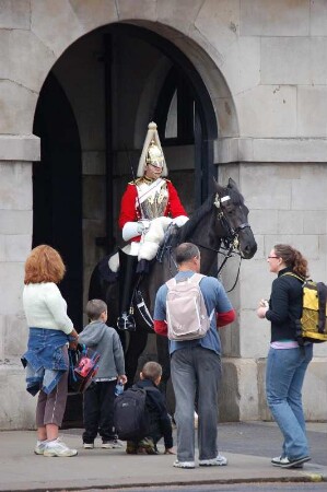 Touristen stehen vor einem Berittenen der Horse Guards, der berittenen Garde der Königin, nur schwarze und weiße Pferde werden verwendet