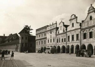 Telč (Teltsch). Marktplatz. Häusergruppe mit Arkaden. Blick zum Schloss