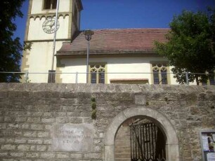 Evangelische Pfarrkirche-Ansicht von Süden mit Kirche (romanische Gründung) über Kirchhofmauer (Wehrgang mit Steinbrüstung und Schießscharten abgetragen) sowie Torbogen (ehemals Kammertor)