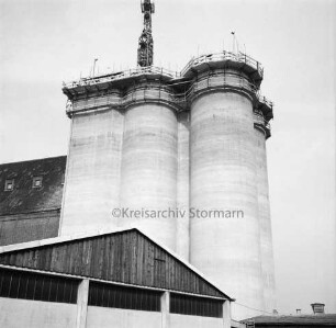 Johannes Ströh Mühlenwerke: Silo-Anlage: am Bahnhof: Getreidesilo in Bau: Beton-Rohbau, oben mit Gerüst: Baukran: links Altbau Silo aus Mauerwerk: vorne Lagerschuppen: Blick von Turmstraße