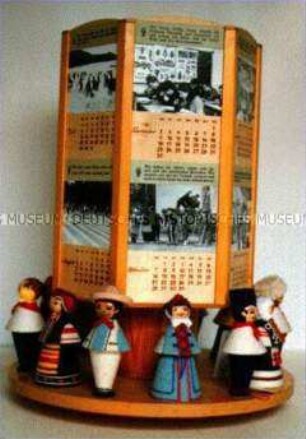 Drehbarer Tischkalender mit internationalen Trachtenpuppen