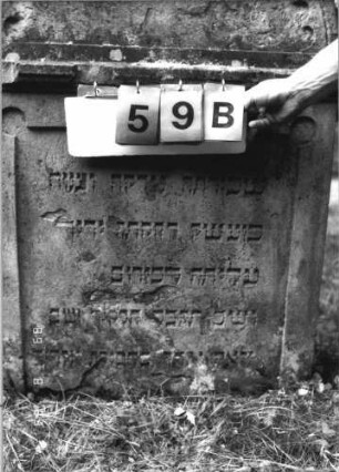 Grabstein 59 (Index: 100110844) Material: Sandstein Zustand: im Giebel stark verwittert mit großem Textverlust, sonst kleine Abschieferungen, am unteren Rand abgebrochen Maße HxBxT: 116x80x16 cm Beschreibung: Stele, Rundbogenabschluß mit Rundbogenfries und Verdachung, Schriftfelder eingetieft: Grabstein 59B