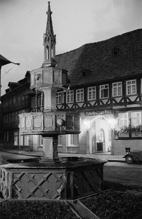 Ansicht des Wohltäterbrunnens in Wernigerode bei Nacht, im Hintergrund das Hotel "Gothisches Haus"
