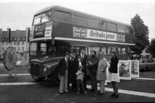 Freiburg: London-Bus auf Tournee am Karlsplatz, mit Singgruppe