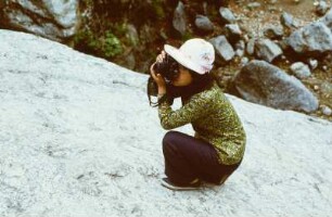 Fotografierende Frau auf einem Felsen