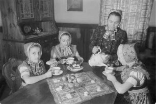 Schleifer Frauen und Mädchen beim Kaffeetrinken nach dem Verzieren von Ostereiern. : Holcy a žony w Slepjanskej drasće po debjenju jutrownych jejkow při kófejpiću pola Wěrikec w Rownom.