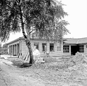 Sporteinrichtungen: Sportanlage am Kortenkamp: Sportlerheim: Sportverein (SV) Großhansdorf von 1942 e. V.: Neubau vor Fertigstellung: davor Handwerker: vorn Sandhaufen und Baumaterial: links Baum