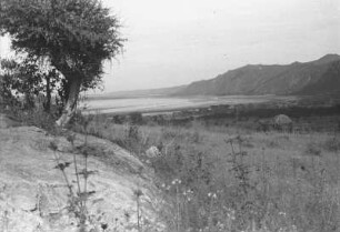 Bruchstufe mit Balangdasee und Hütte : Savanne mit Bergkette und davorgelagertem Balangdasee, an dem Hütten stehen
