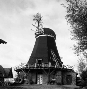 Siebenbäumen (Kreis Herzogtum Lauenburg): Siebenbäumener Mühle: Restaurierung: unten an Wand Teile des Mahlwerks: oben auf Galerie Leiter: rechts Baum: links Lieferwagen und restauriertes Fachwerkhaus von Gut Trenthorst