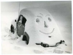 Dick verschneites Auto mit Spaßgesicht im Schnee
