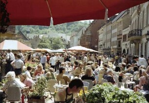 Freiburg: Roter Schirm, Münsterplatz mit Tischen, Hintergrund Kaufhaus