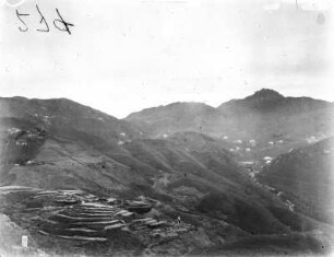 Siedlung : Blick auf eine an Berghängen erbaute Siedlung. Im Bildvordergrund einige Feldterrassen