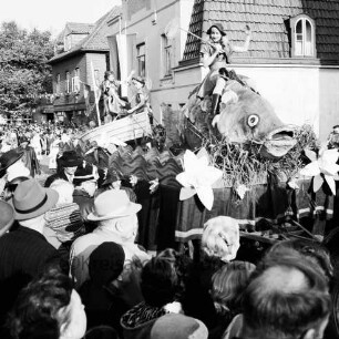Karpfenfest: Umzug: Festwagen, Fischerin reitet auf Riesenkarpfen, Fischerinnen in Boot: umgeben von Zuschauern: hinten Fahnenschmuck, Wimpelgirlanden, 13. Oktober 1957