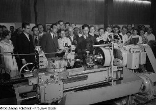 Besucher des chinesischen Pavillons der Leipziger Herbstmesse 1954 betrachten die Vorführung einer Industriemaschine