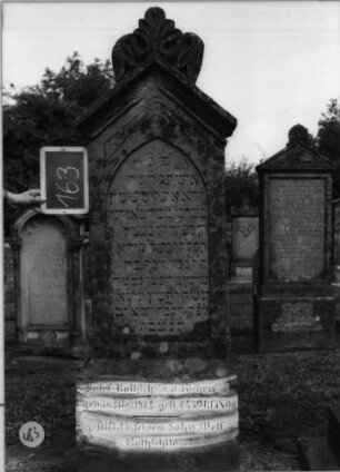 Grabstein 483 (Index: 100086836) Material: Sandstein Zustand: verwittert Maße HxBxT: 185x60x30 cm Beschreibung: Stele auf Sockel mit Dreiecksgiebel und Ornamentenaufsatz: Grabstein 483