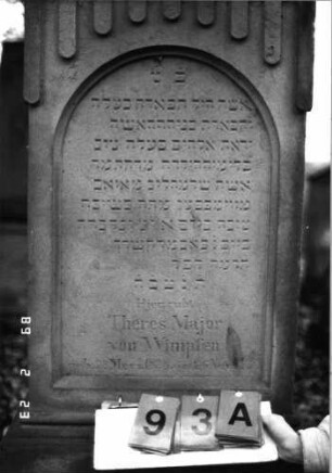 Grabstein 93 (Index: 99751857) Material: Sandstein Zustand: gut, ein Akroter weggebrochen Maße HxBxT: 168x57x25 cm Beschreibung: giebelart. Abschl. m. Mittel-u. Eckakrot. /Schriftfeld eingetieft m. Rundbogenabschl. , Symbolik: Ranken, gestelztes Rundbogenfries Besonderheit: Zitat Proverbia 12, 4 und 31, 10: Grabstein 93A