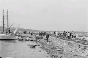 Reisefotos Griechenland. Delos (Insel). Ankerndes Segelboot. Am Strand Touristen, Souvenirverkäufer und Fischer