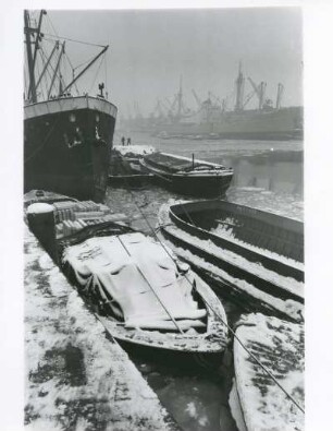 Hamburg. Winter im Hafen. Verschneite Leichter liegen am Kai. Das Hafenbecken ist teilweise zugefroren