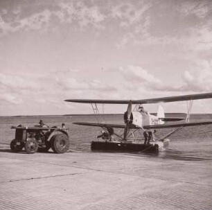 Rostock-Warnemünde. Deutsche Verkehrsfliegerschule, Zweigstelle Seefliegerschule Warnemünde. See-Schulflugzeug Heinkel HD-24 wird nach der Wasserlandung von einem Traktor an Land gezogen