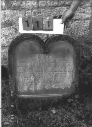 Grabstein 111 (Index: 99609747) Material: Sandstein Zustand: verwittert Maße HxBxT: 66x59x11 cm Beschreibung: Doppelstele für Zwillingsgeschwister (links: Fanny, rechts: Max), jeweils Rundbogenabschluß, Schriftfeld eingetieft, kein Mittelsteg Besonderheit: Doppelgrab für Zwillingsgeschwister; - Kindergrab: Grabstein 111