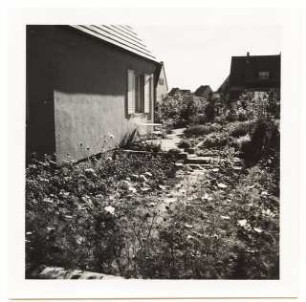 Garten Fröhlich, Kleinmachnow: Sitzplatz am Haus mit Sommerblumen