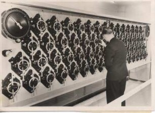 Gezeitenmaschine : Hamburg. Hydrographisches Institut (heute Bundesamt für Seeschifffahrt und Hydrographie). Ein Mitarbeiter steht vor der weltweit größten Gezeitenmaschine