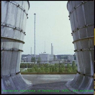 Blick durch die Kühltürme des Mehrzweckforschungsreaktors (MZFR) auf die Kompakte Natriumgekühlte Kernenergieanlage (KNK), von Norden