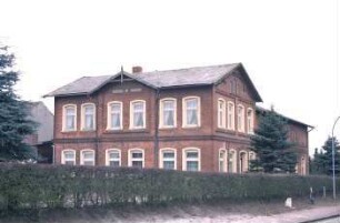 Hauptstraße 26: Bauernhaus aus Backstein, mit umlaufendem Gesims: giebelständiges Wohnhaus: Traufseite mit Mittelrisalit, Frontispiz mit Giebelpfahl: Straßenfront mit Eingangstür: rechts traufständiger Wirtschaftstrakt: links rückwärtige Wirtschaftsgebäude: vorne Gartenhecke