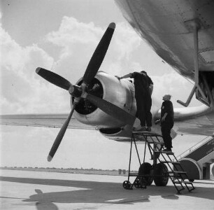 Leipzig-Mockau. Flughafen, Vorfeld. Zwei Techniker bei Wartungsarbeiten an einem Flugzeugmotor