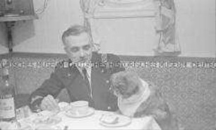 Heimfahrt der Kriegsgefangenen vom Internierungslager "Angel Island" auf dem italienischen Dampfer "Fella", Kapitän mit Hund am gedeckten Tisch im Speisesaal