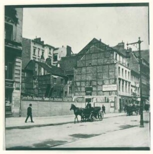 unbekannte Straße mit Pferdefuhrwerk und Baulücke