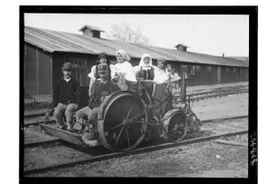 Männer und Frauen auf einer Draisine : Rumänien? 1. Weltkrieg. Blumengeschmückte Draisine mit Männern und Frauen in einem Bahnhof, 1918