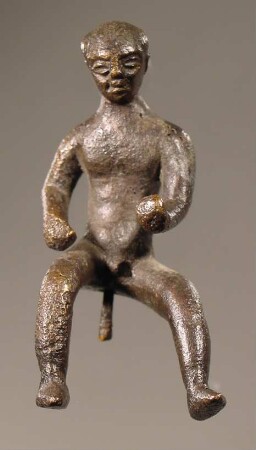 Statuette eines nackten sitzenden Jünglings mit vorgestreckten Armen