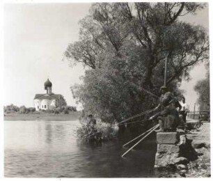Arkash bei Nowgorod, Russland. Kirche Mariä Verkündigung (1179). Blick von Osten über den See, im Vordergrund Angler