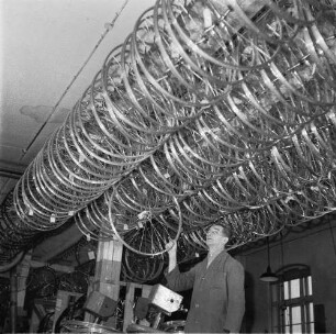 Siegmar-Schönau (Chemnitz-Siegmar). VEB Fahrradwerke Elite Diamant. Mitarbeiter in einem Lagerraum mit Rädern