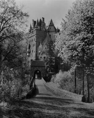 Wierschem. Burg Eltz (Ersterwähnung 1157, Teilzerstörung (Brand) 1920, Wiederherstellung bis 1939). Gesamtansicht der Ganerbenburg von Nordosten mit Blick durch den Torweg zum äußeren Torbau