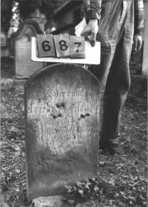 Grabstein 687 (Index: 99788418) Material: Sandstein Zustand: sehr stark verwittert im unteren Teil Maße HxBxT: 69x37x8 cm Besonderheit: Kindergrab: Grabstein 687