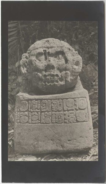 Sculpture en pierre avec des hiéroglyphes en forme de siège avec dossier (vue de face).