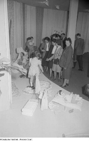 Besucher vor einem Messestand mit Kinderbekleidung im Ring-Messehaus