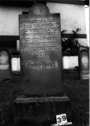 Grabstein 39 (Index: 99804557) Material: Sandstein Zustand: leicht verwittert, Sockel stark verwittert mit Textverlust Maße HxBxT: 142x50x16 cm Beschreibung: Stele, Sockel, eingezogener Rundbogenabschluß Besonderheit: Sockel gehört nicht zu diesem Stein -> siehe freie Kommentierung: Grabstein 39